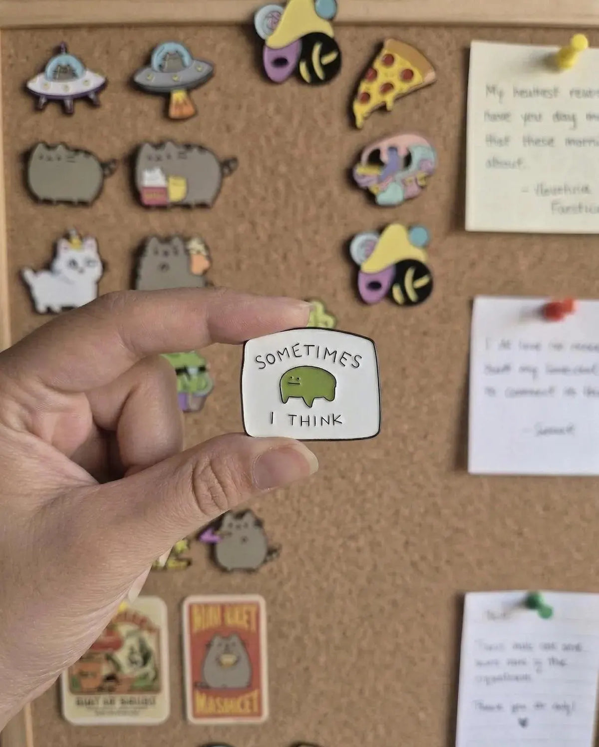 A hand holds a small enamel pin with a green cartoon creature and the text 'SOMETIMES I THINK' in front of a yellow tote bag and a blurred desk background with books. Cute Frog Enamel Pin, “Sometimes I Think” Meme Pin, Funny Relatable Gift, Mental Health Pin, Kawaii Green Pin, ADHD Pin, Gift for Friends