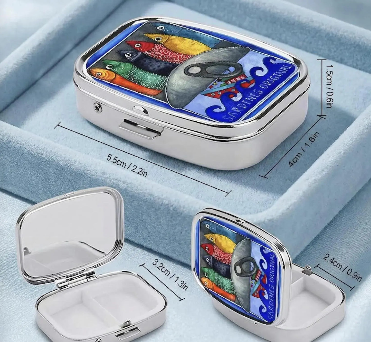 A small rectangular tin with a colorful fish illustration and the text 'PERSIMMA' sits on a light blue plate with scattered pastel candies. The background shows a softly blurred indoor setting with curtains and a table surface. Sardines Pill Case, Pocket Size Metal Mint Holder, Refillable Pill Box, Cute Kawaii Portuguese Art Accessory, Small Gifts, Pill Organizer